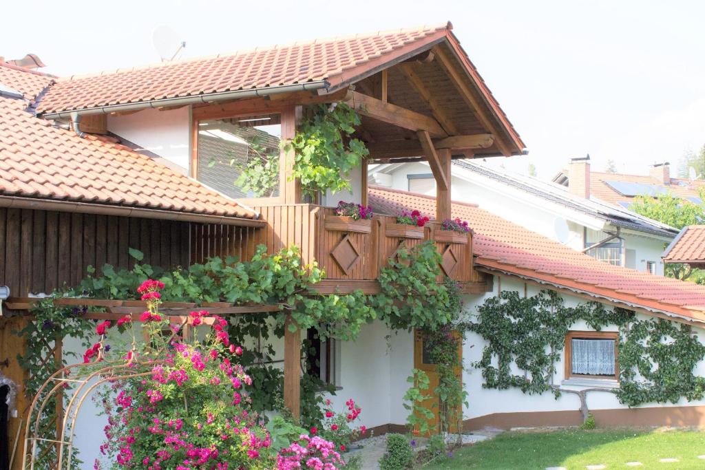 una casa con un balcón con flores. en Ferienwohnungen Irene Konstandin, en Bischofsmais