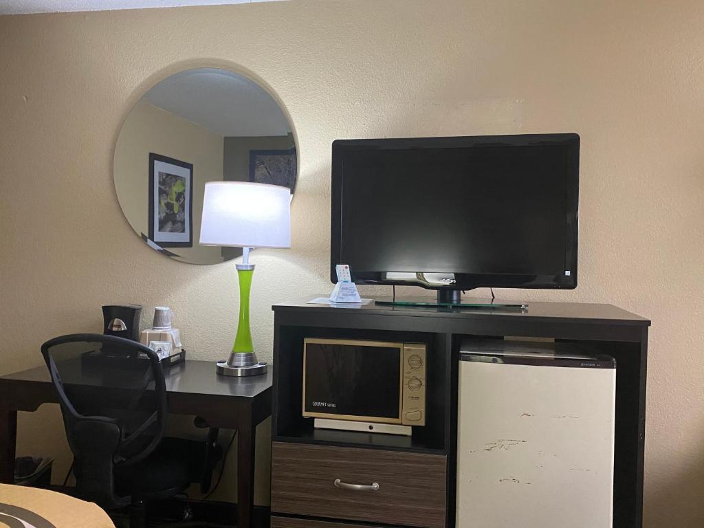 a room with a desk with a tv and a computer monitor at Super 8 by Wyndham Maysville KY in Maysville