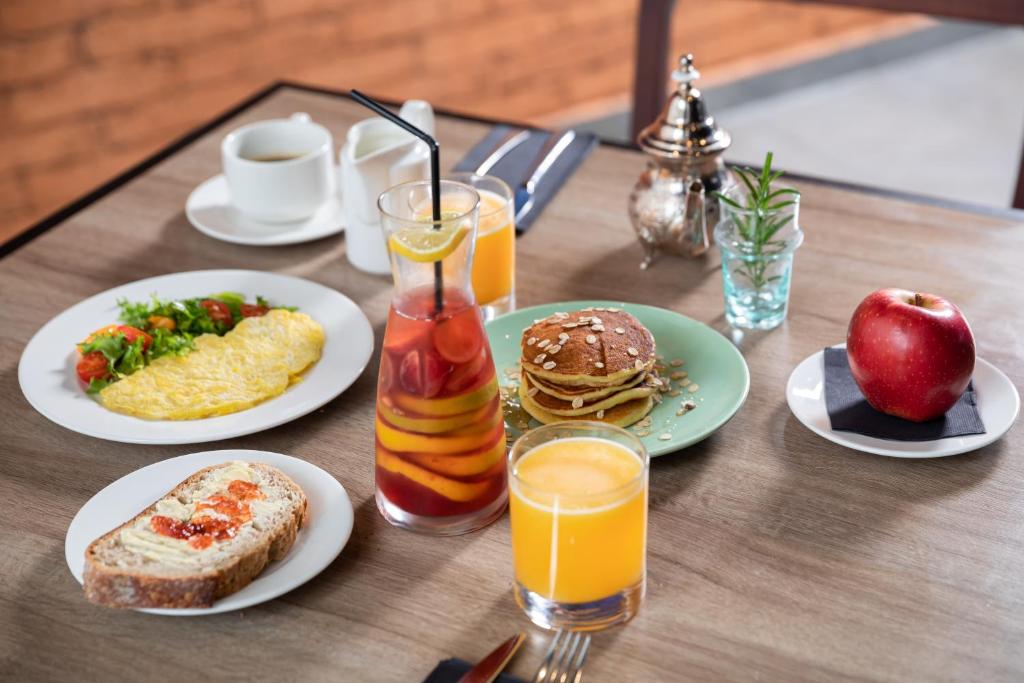 a table with plates of breakfast foods and orange juice at ONOMO Airport Casablanca in Casablanca