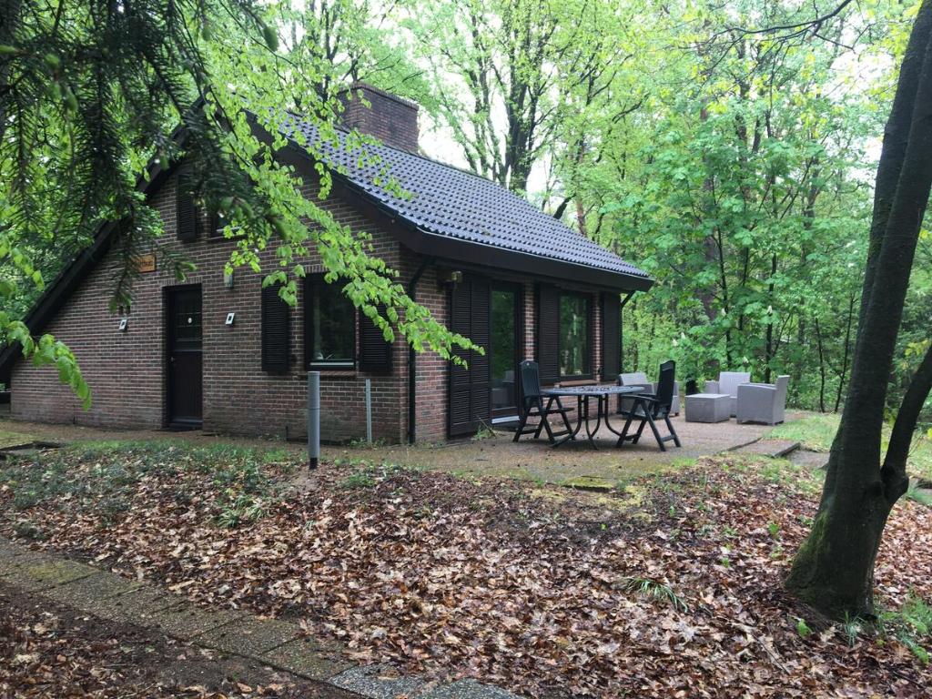 una cabaña de ladrillo con una mesa de picnic delante de ella en 't Aarthuis en Emst