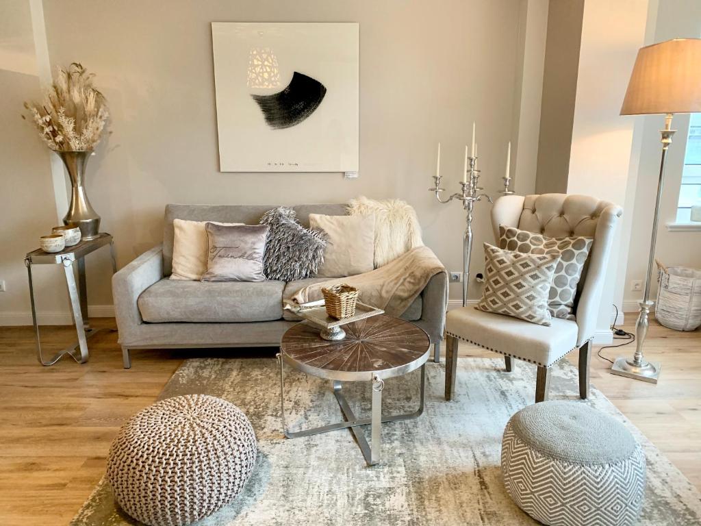 a living room with a couch and a table and chairs at Inselliebe Deluxe Apartement/ Studio in Westerland