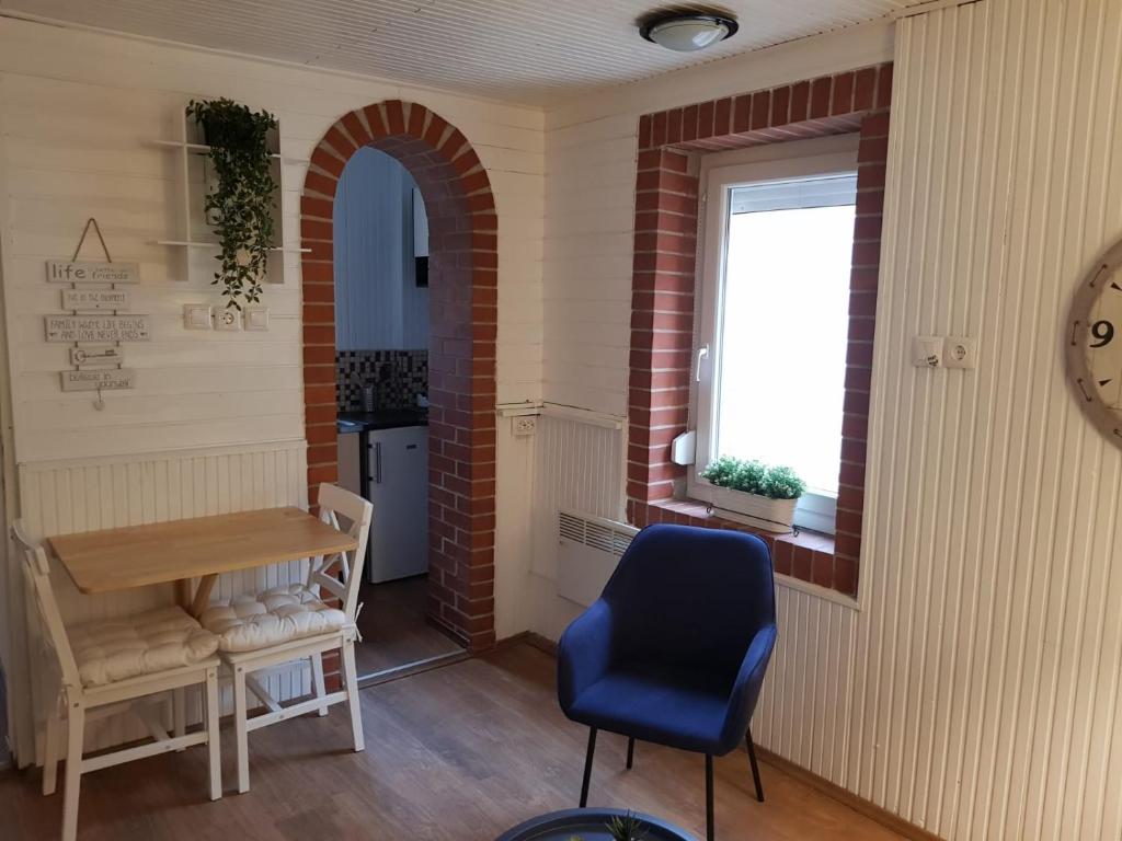 Zimmer mit einem Tisch, einem Stuhl und einem Fenster in der Unterkunft Het Huisje Klein maar Fijn in Bár
