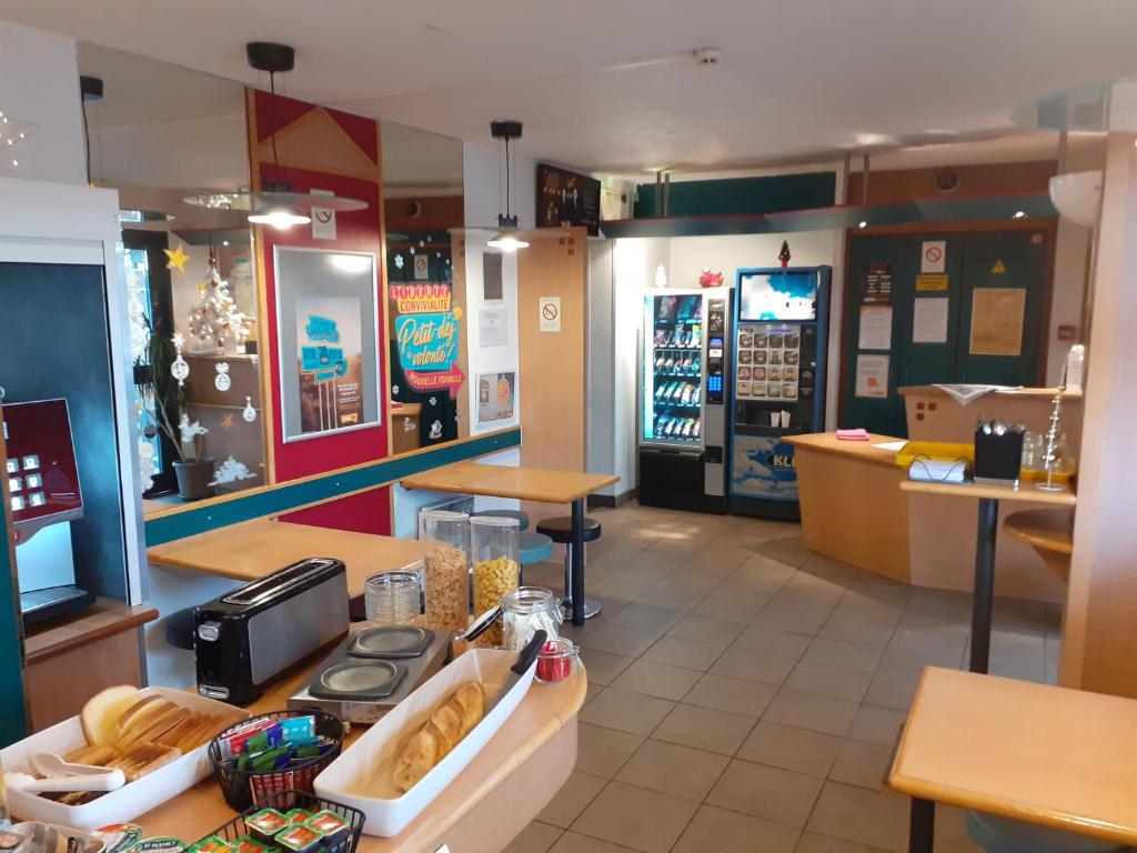 um restaurante de fast food com uma loja de donuts com um balcão em hotelF1 Epinal Nord em Épinal