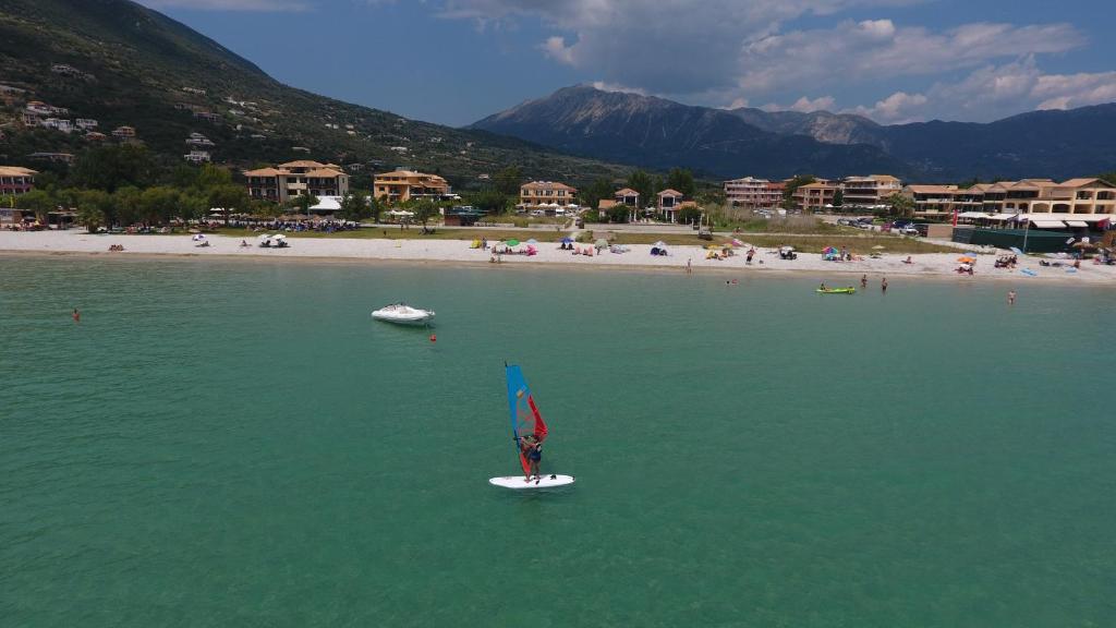 eine Person auf einem Surfbrett im Wasser in der Nähe eines Strandes in der Unterkunft Hotel Odeon in Vasiliki