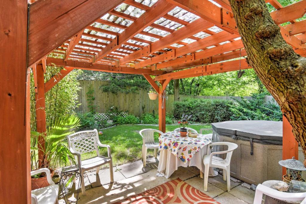 a patio with a table and chairs under a wooden pergola at Private Home with Hot Tub and Patio Near Downtown Tulsa in Tulsa
