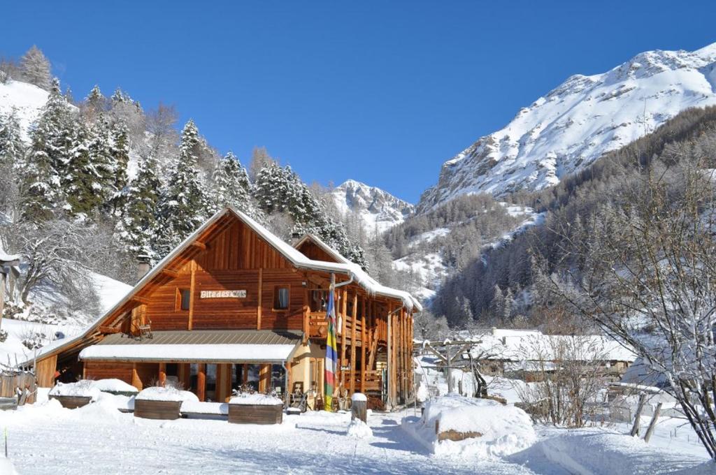 uma cabana de madeira na neve com montanhas ao fundo em Gîte les 3 cols em Réallon