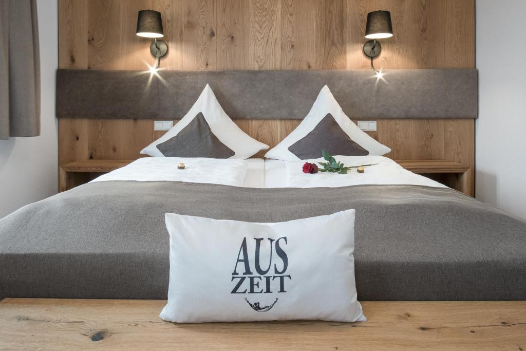 a bedroom with a bed with a us zitt pillow at Seehof am Waginger See in Petting