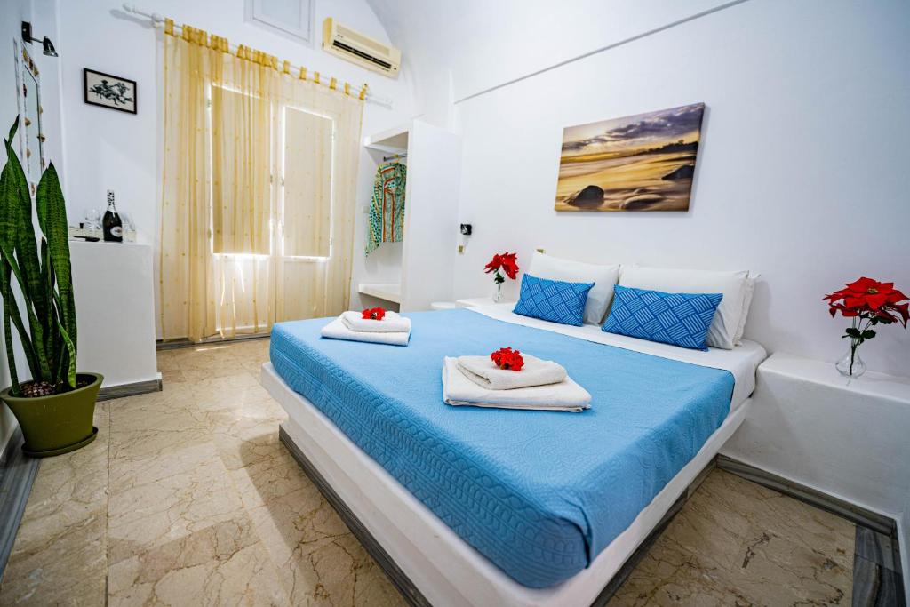 1 dormitorio con 1 cama con toallas en Join Us Low Cost Rooms, en Kamari