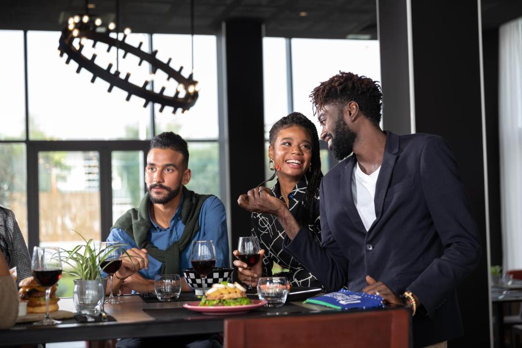a group of people sitting at a table with wine glasses at ONOMO Airport Casablanca in Casablanca