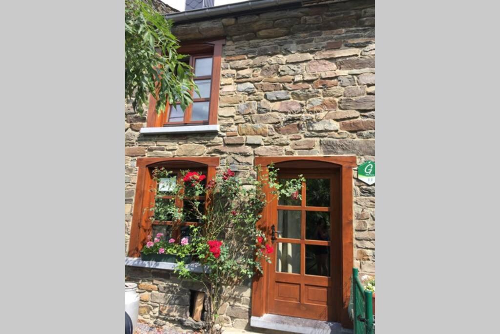 une maison en pierre avec une porte et des fenêtres en bois dans l'établissement Vieux Logis een prachtige Ardeense vakantiewoning, à Vresse-sur-Semois