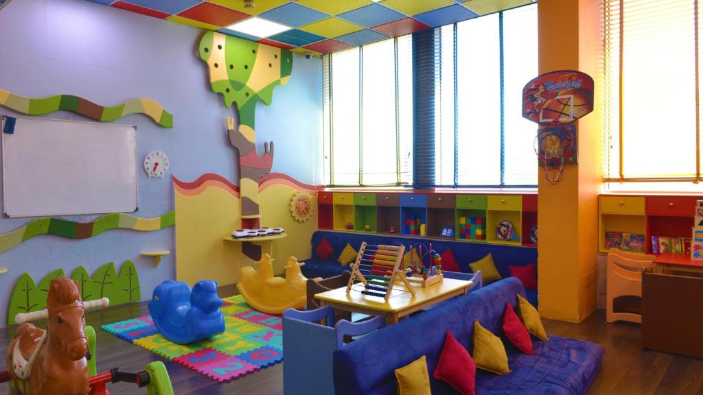 Habitación infantil con zona de juegos con sofá y mesa en Holiday Inn Kuwait Al Thuraya City, an IHG Hotel, en Kuwait