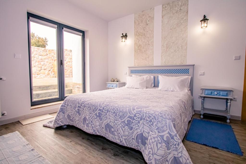1 dormitorio con cama y ventana grande en A Queijaria, en Barreira