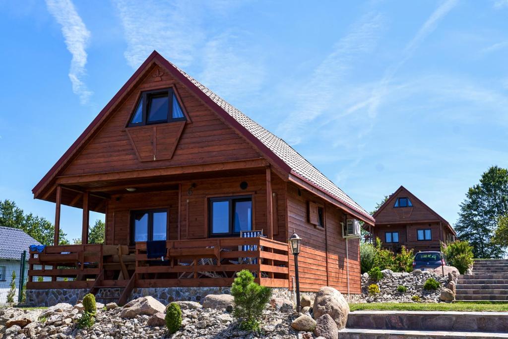 uma cabana de madeira com um telhado de gambrel em Osada Łagówek - domek letniskowy do wynajęcia em Łagów