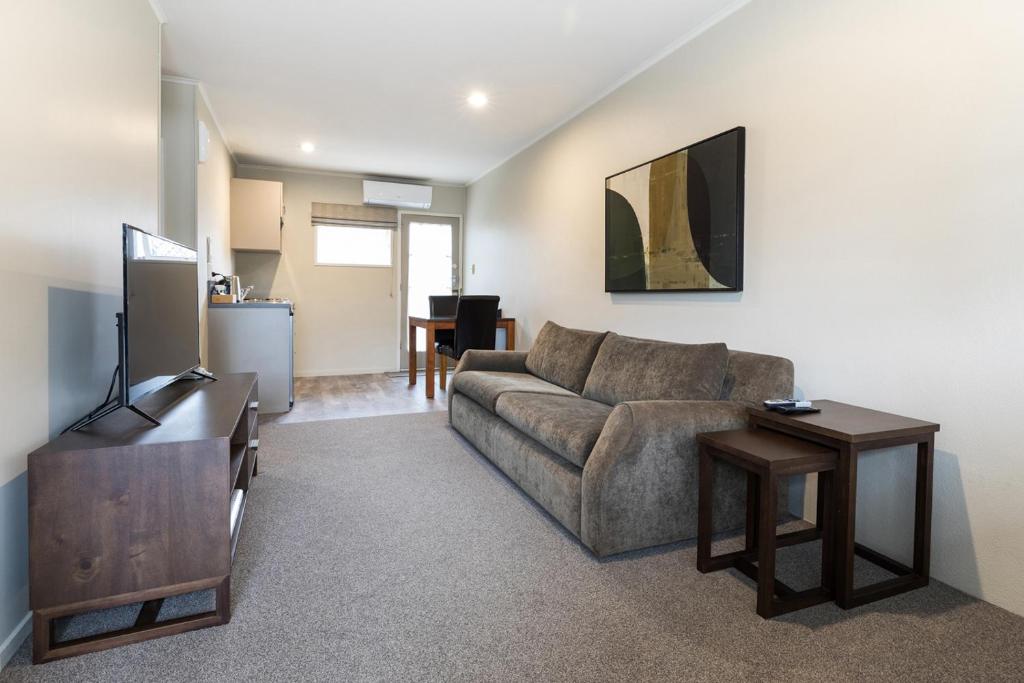 a living room with a couch and a table at Colonial Court Motor Inn in Tauranga