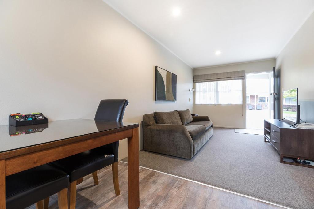 a living room with a couch and a table at Colonial Court Motor Inn in Tauranga
