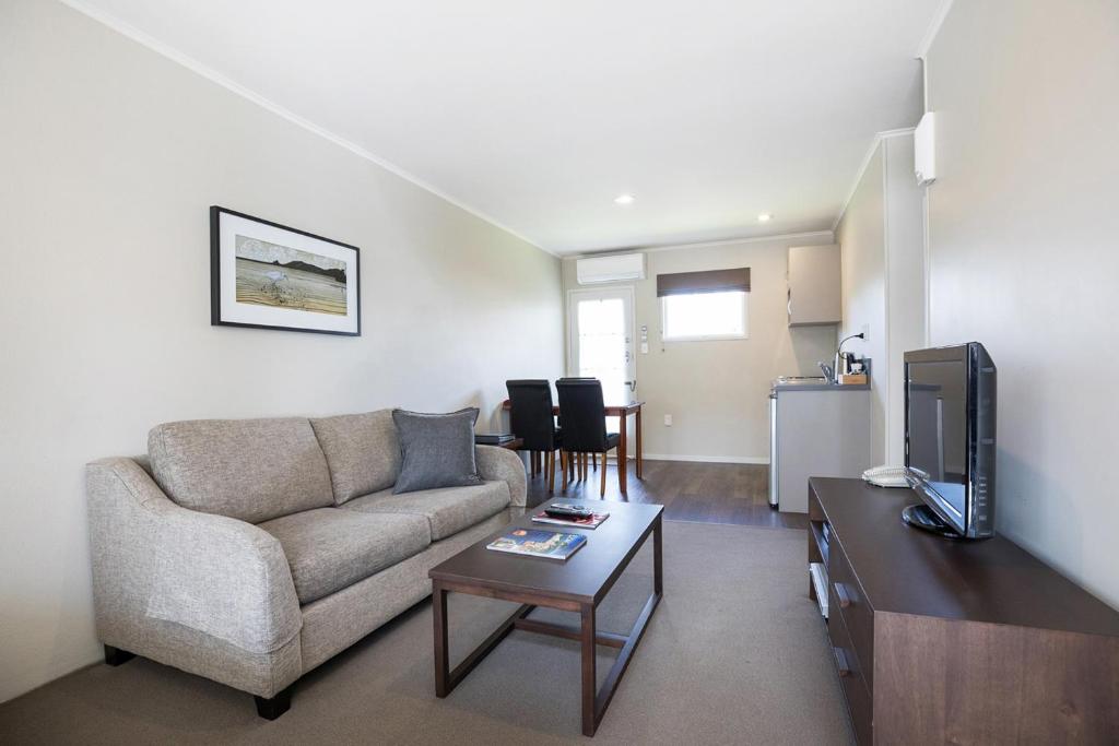 a living room with a couch and a table at Colonial Court Motor Inn in Tauranga