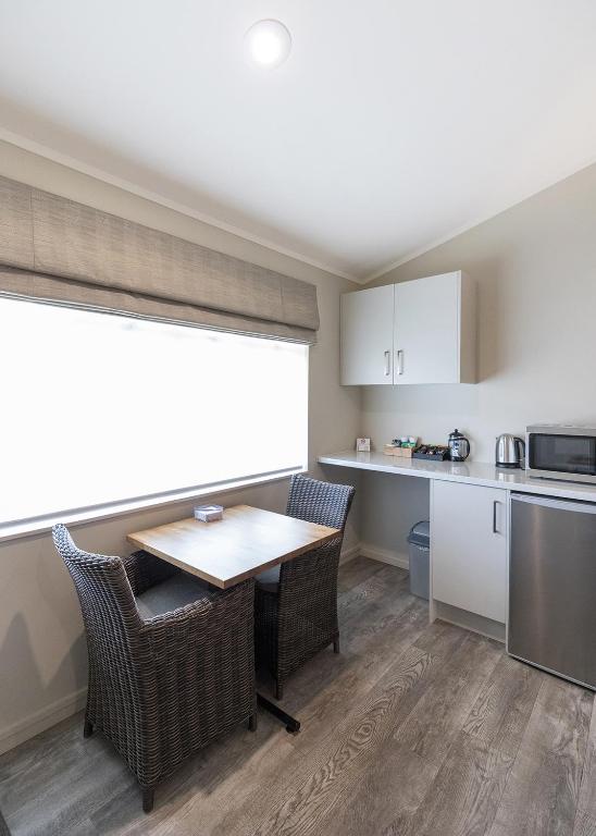 a small kitchen with a table and chairs and a counter at Colonial Court Motor Inn in Tauranga