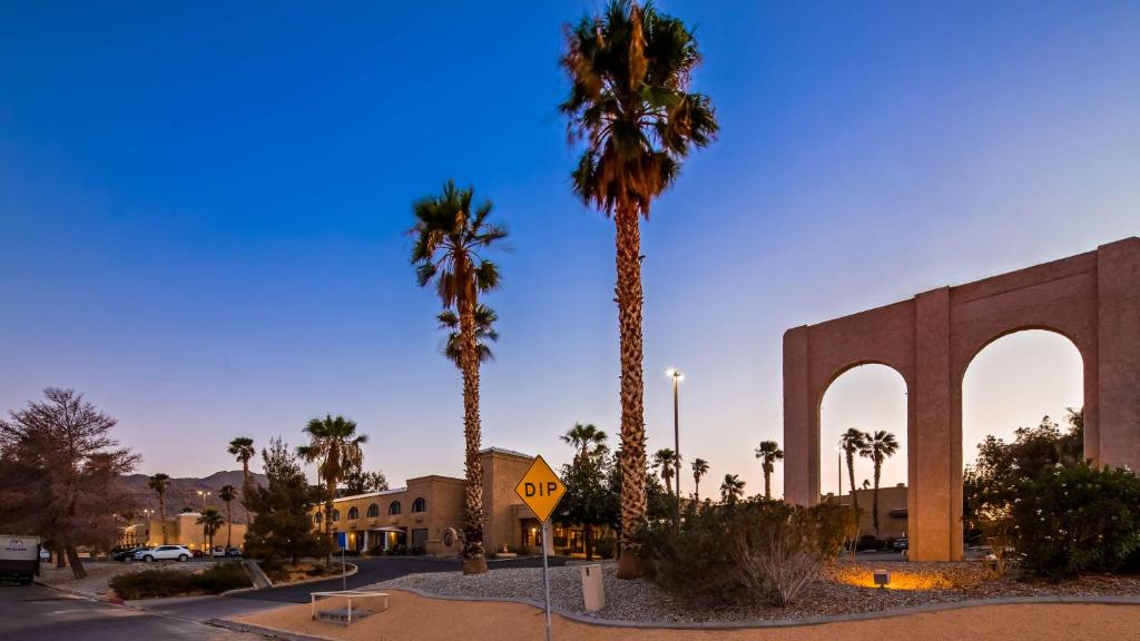 a large palm tree in front of a large building at Sure Stay Plus by Best Western Twentynine Palms Joshua Tree in Twentynine Palms