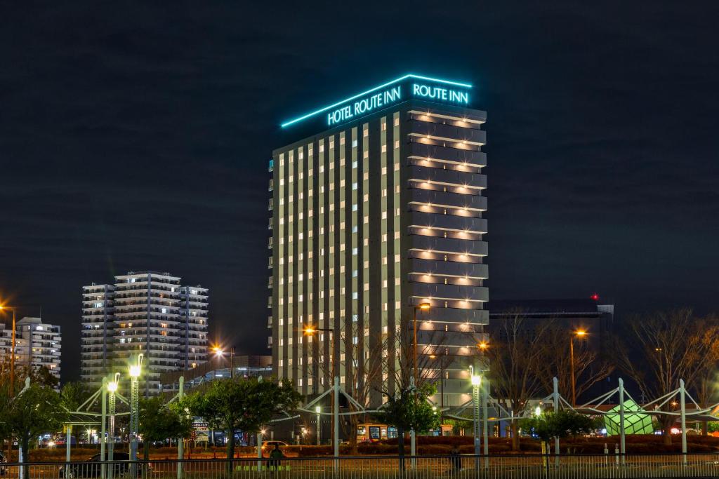 印西市にあるホテルルートイン千葉ニュータウン中央駅前-成田空港 アクセス線-の夜間の看板が貼られた高層ビル