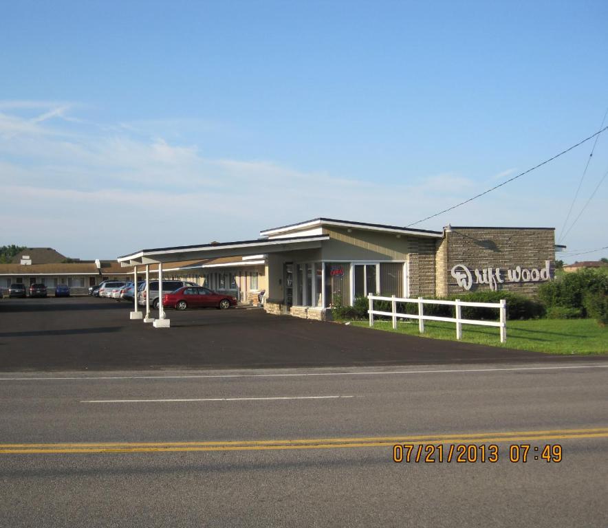 a building on the side of a street with a car dealership at Driftwood Motel in Niagara Falls