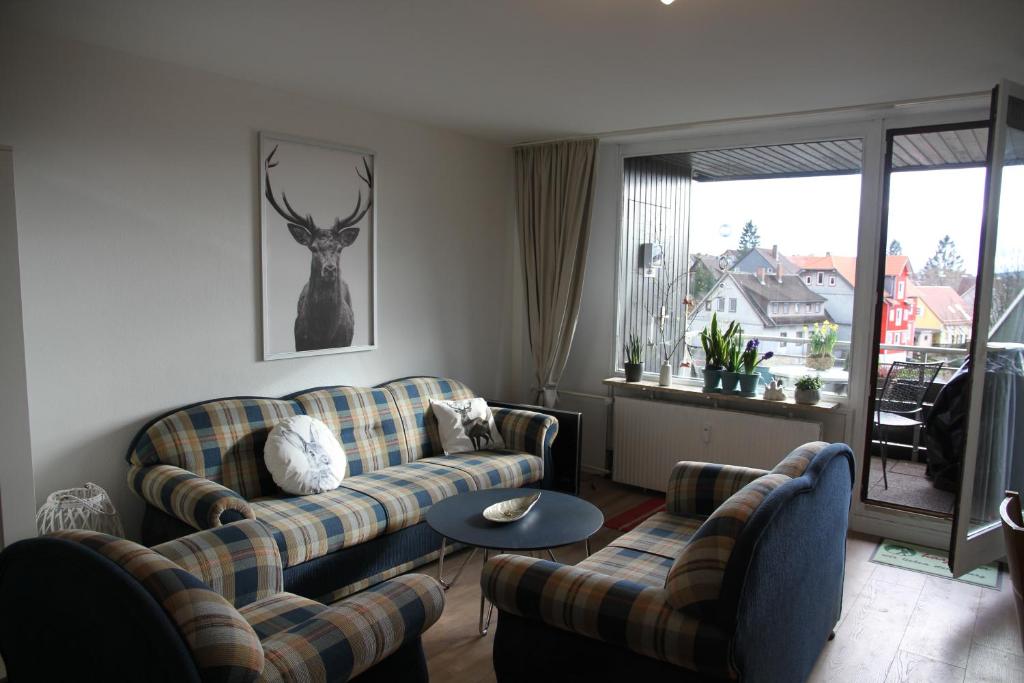 ein Wohnzimmer mit Sofas und einem Hirsch an der Wand in der Unterkunft Apartment am Kurpark in Sankt Andreasberg