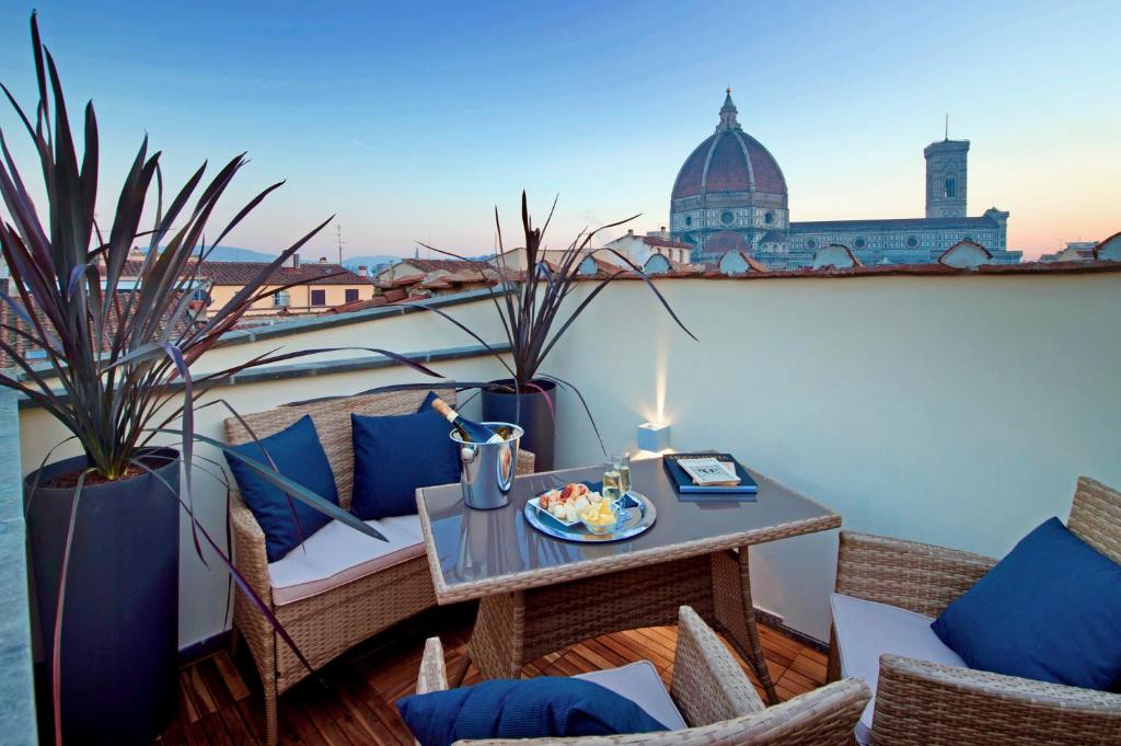 a table and chairs on a balcony with a candle at Arte' Boutique Hotel in Florence