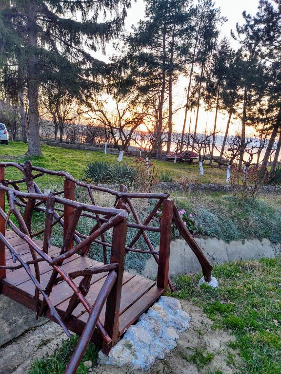 a wooden bench in a park with the sunset in the background at Dedinski Raj in Golubac