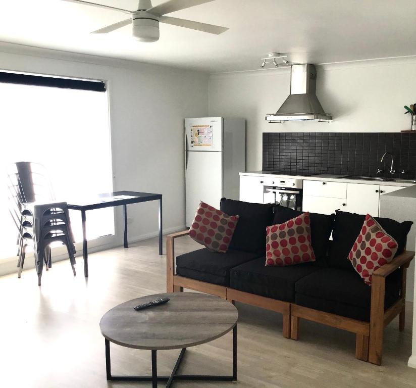 a living room with a couch and a table at Ocean View Villas in Vincentia