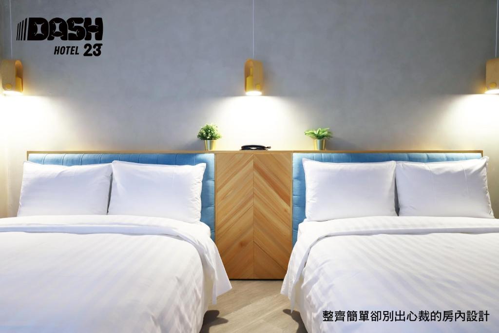 2 camas con sábanas blancas en una habitación en Dash 23 Hotel en Tainan