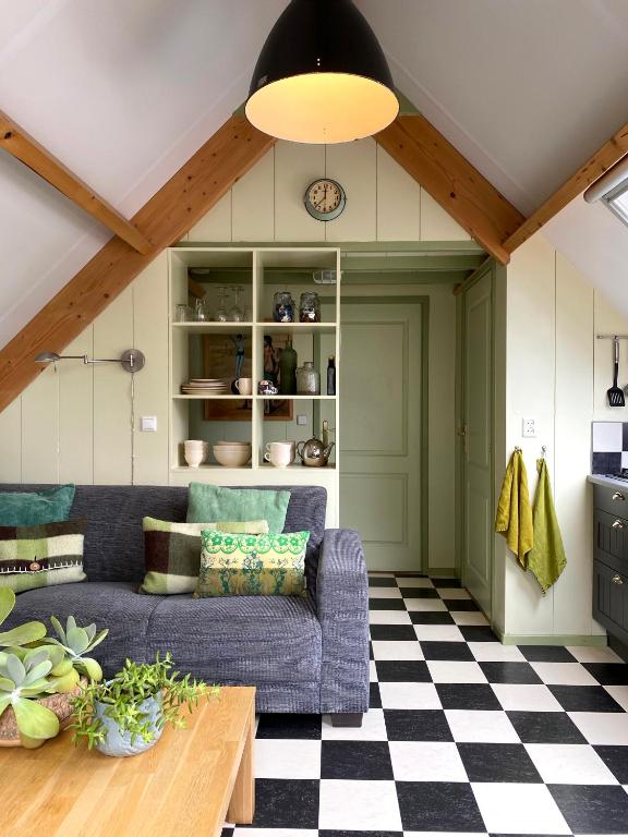a living room with a blue couch and a checkered floor at Apartment In de Wolken in Oostwoud