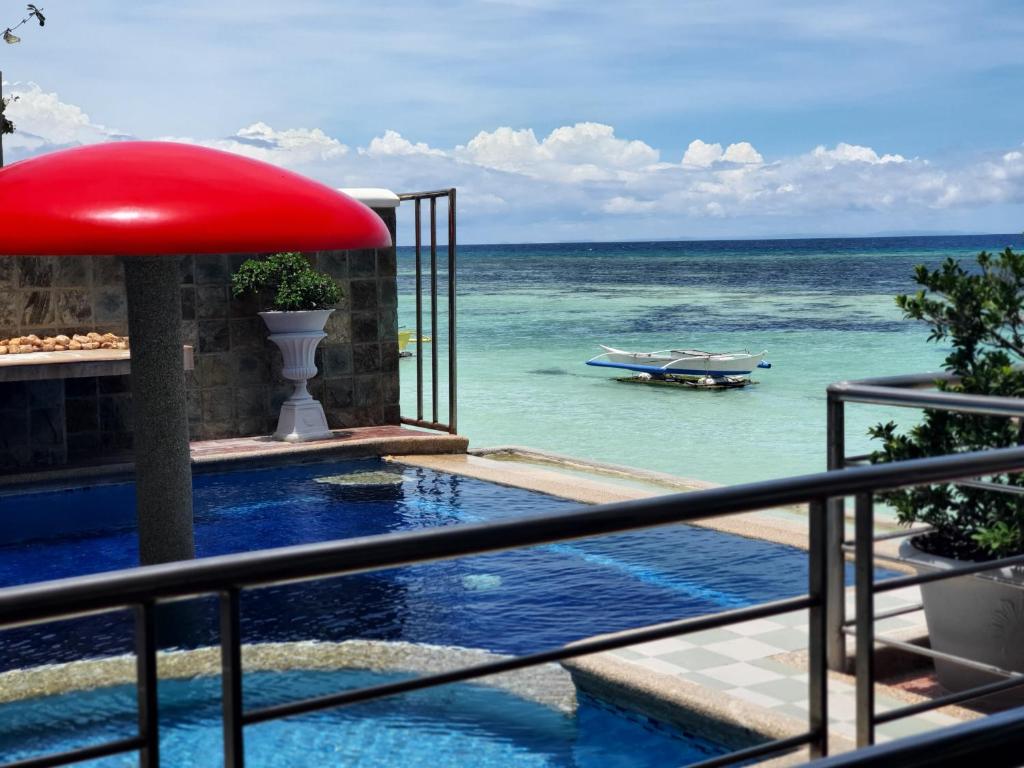 una piscina con vistas al océano en L & M Hearthstones Lodge, en Oslob