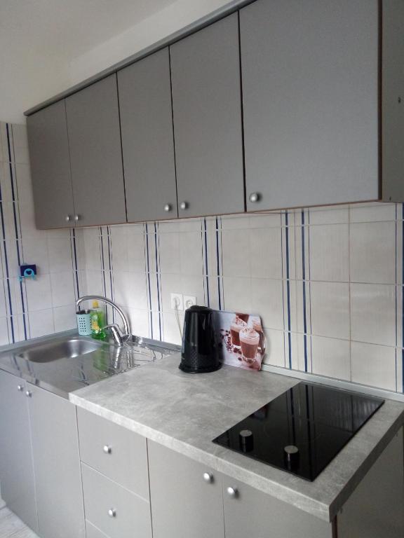 a kitchen with white cabinets and a sink at KATY&MLADEN in Baška
