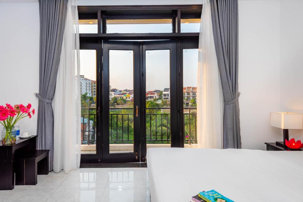 Postel nebo postele na pokoji v ubytování Flamingo Villa Homestay - Big Rooms with Balcony - Close to Hoi An Old Town 200m & Temple Bridge - Large Outside Pool for Sun Bathing