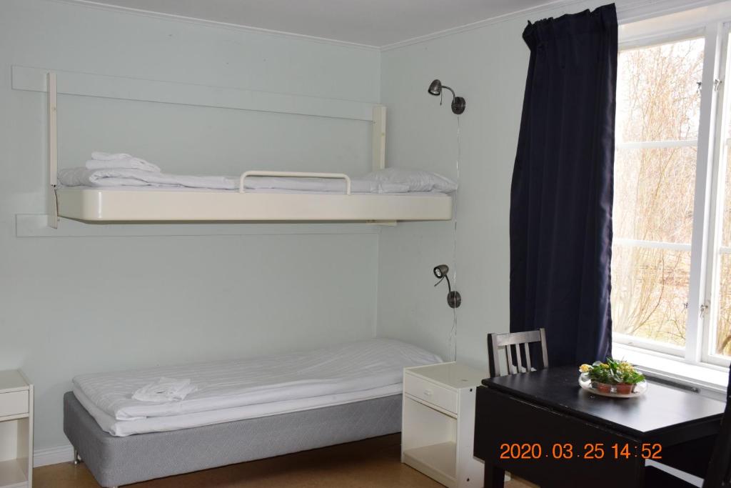 a bedroom with a bunk bed and a window at STF Kapellskär Hostel in Gräddö