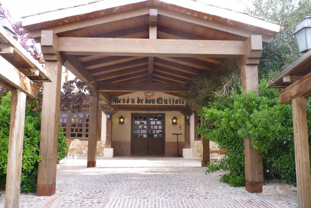 a wooden entrance to a building with a wooden pergola at Hotel Mesón de Don Quijote in Mota del Cuervo