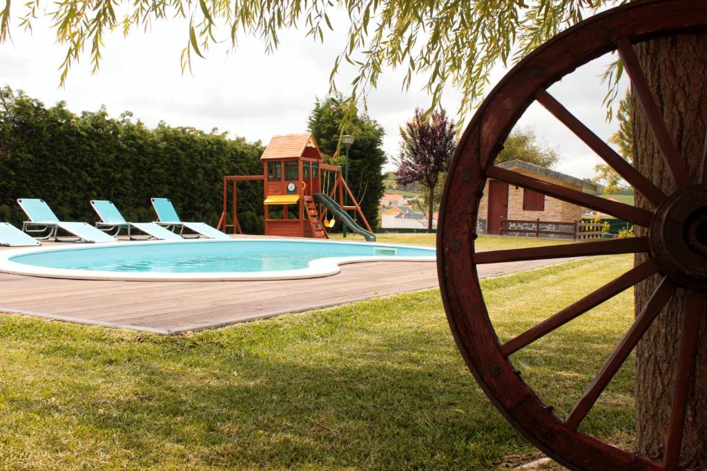 une piscine avec des chaises longues et une aire de jeux dans l'établissement Quinta Sobral Prestige - Rustic House, à Sobral de Monte Agraço