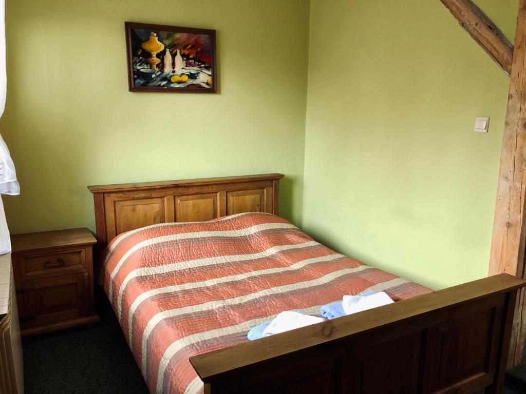 a bedroom with a bed and a picture on the wall at Karczma Młyn in Kamienica