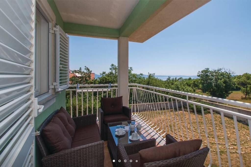 een veranda met stoelen en een tafel op een balkon bij Comfortable apartment in Bartići in Labin