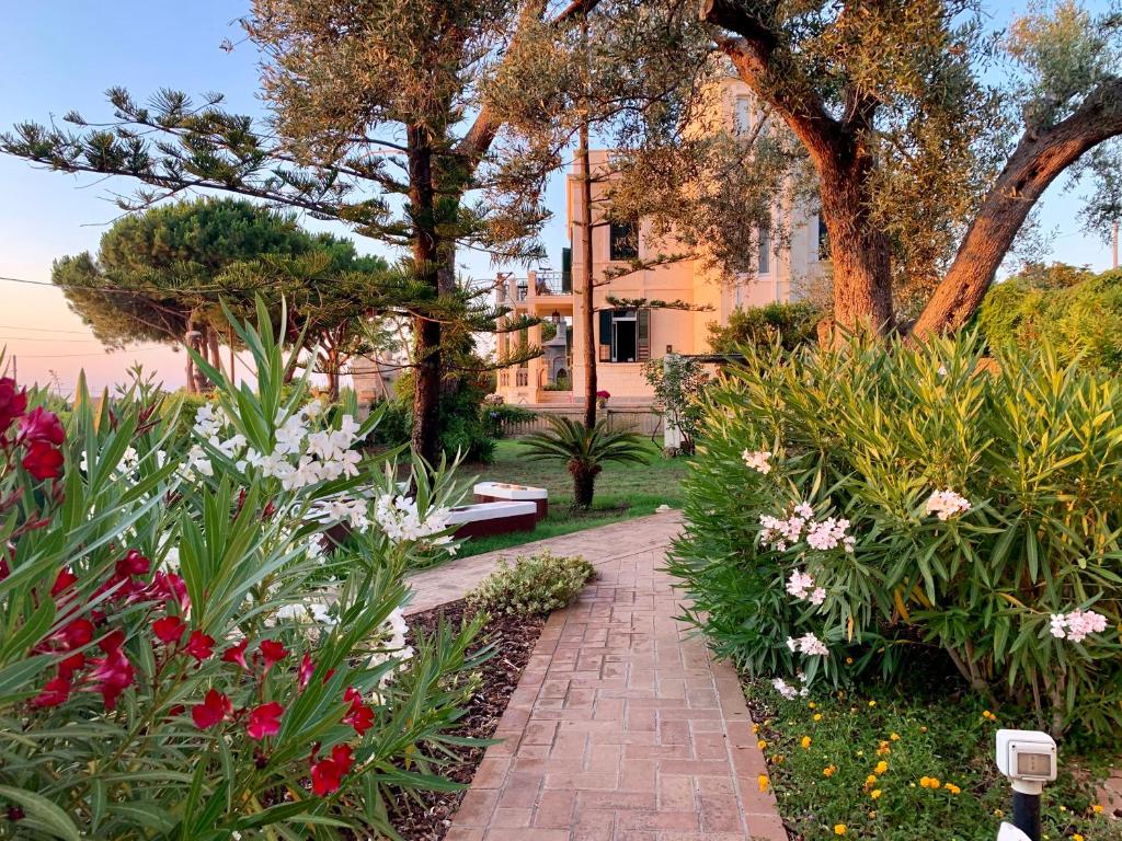 a garden with a brick path and flowers at Villino Eleonora in Parghelia