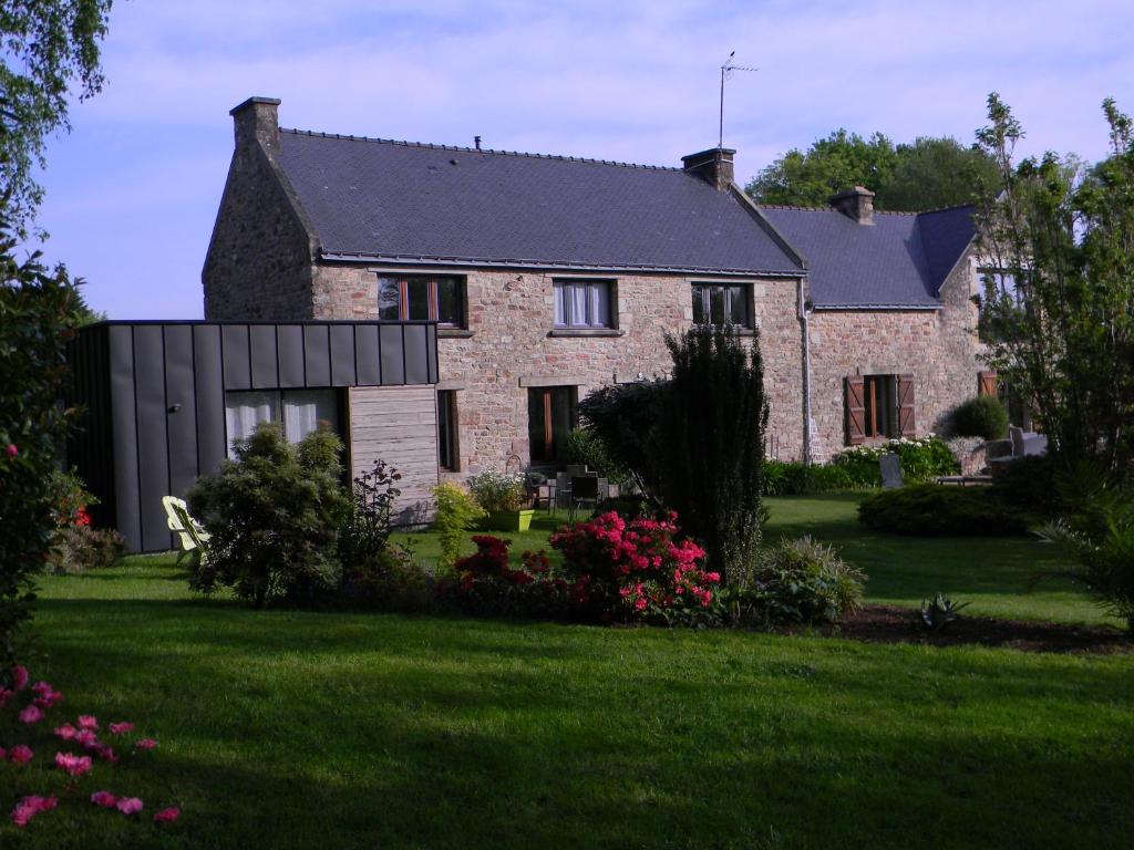 une grande maison en briques avec une cour verdoyante dans l'établissement Les Jardins du Cloestro, à Kervignac