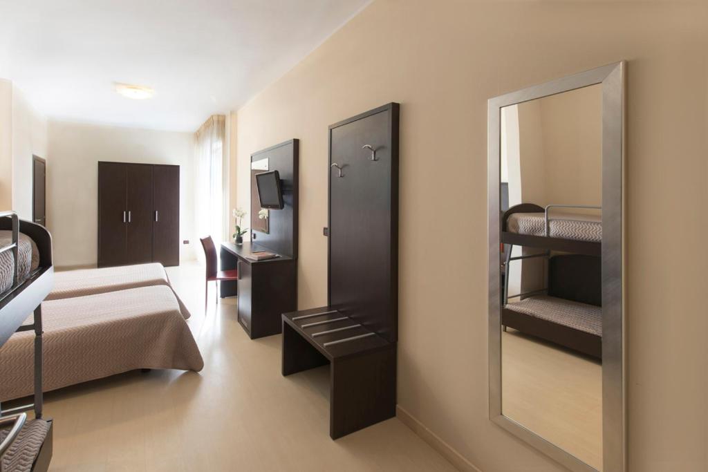 Zimmer mit einem Schlafzimmer mit einem Bett und einem Spiegel in der Unterkunft Grand Hotel Adriatico in Montesilvano