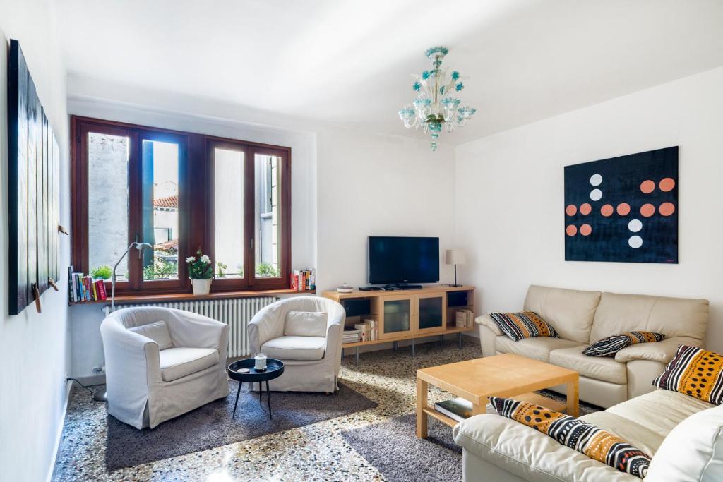 ein Wohnzimmer mit 2 Sofas und einem TV in der Unterkunft ACQUARELLO - Like at home in heart of Venice in Venedig