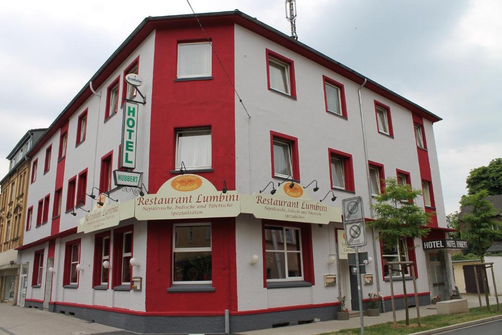 a red and white building on the corner of a street at Hotel Hubbert in Castrop-Rauxel