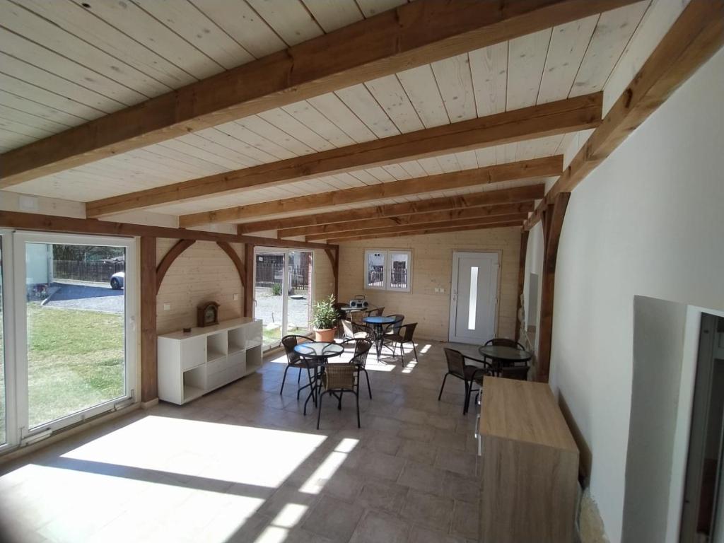 una sala de estar con techos de madera, mesas y sillas en Villa Šimák, en Staré Splavy