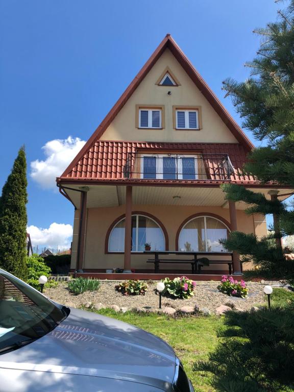 a house with a car parked in front of it at Pensjonat Krzyś in Nielisz