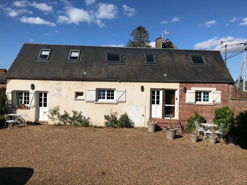 a white house with a black roof at La Treille in Noyers-Saint-Martin