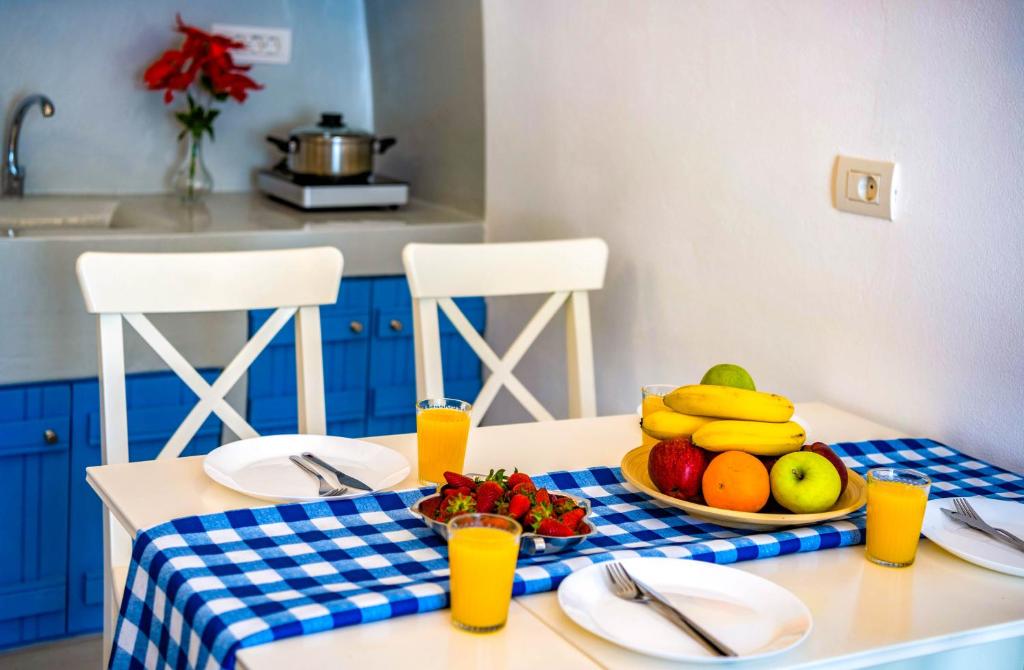 a table with a plate of fruit on top of it at Bonita Santorini Cave in Éxo Goniá