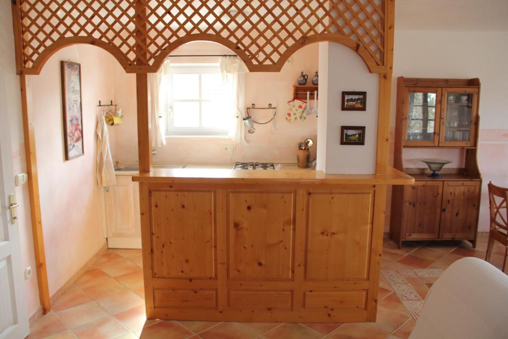 a kitchen with wooden cabinets and a window at ALPHA in Badacsonytördemic