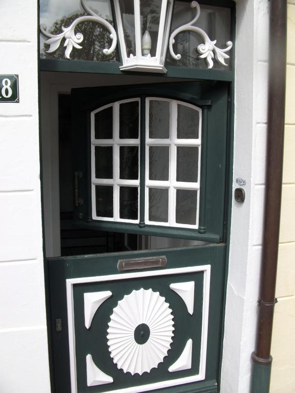 a green door with a painting on it at up Stuuv in Greetsiel