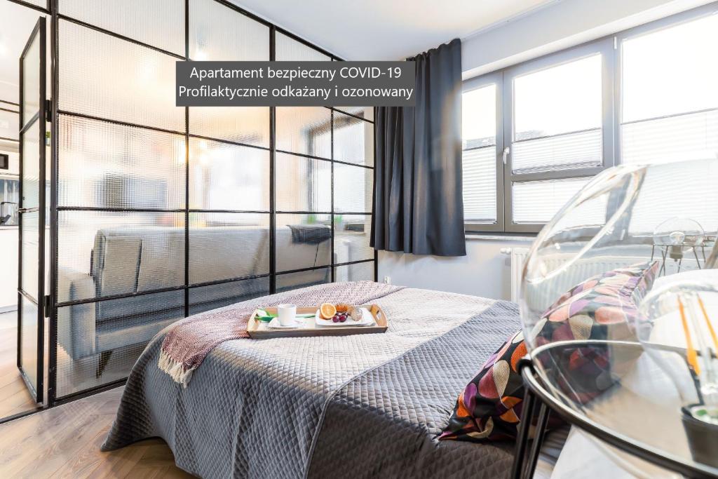 een kamer met een bed en een dienblad met eten erop bij Ideal Apartments Green & Blue in Gdańsk